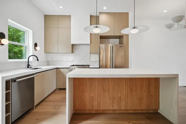 a kitchen with stainless steel appliances a sink a refrigerator and a stove