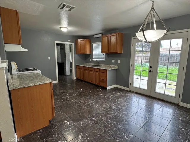 a kitchen with stainless steel appliances granite countertop a stove a sink a refrigerator and a wooden cabinets