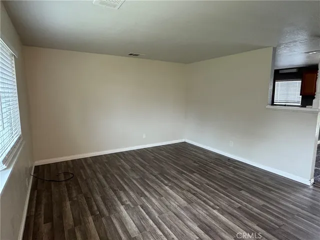 a view of an empty room and wooden floor