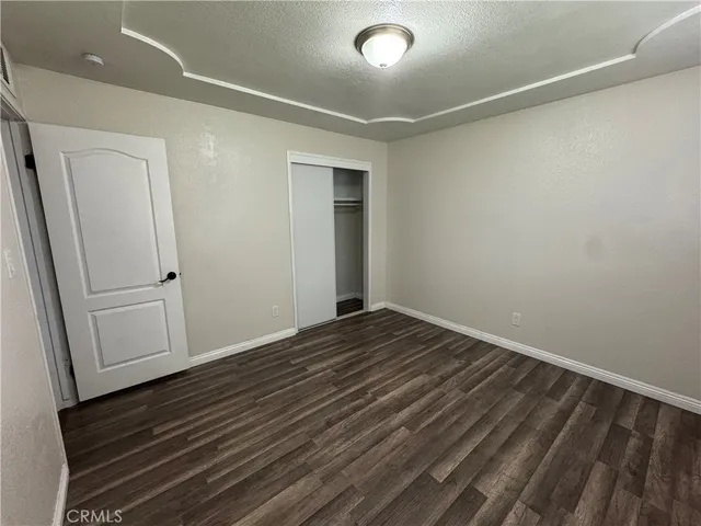 a view of a room with wooden floor and white walls