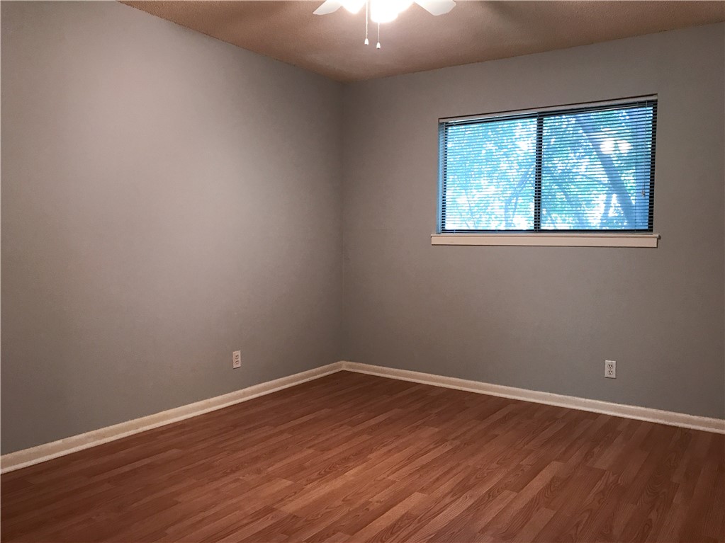 5001 Bull Creek Road, Unit 116 Austin, TX 78731 - Photo 5 of 6 an empty room with wooden floor and windows