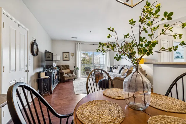 a dining room with furniture potted plants and wooden floor