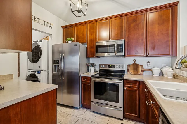 a kitchen with stainless steel appliances granite countertop a refrigerator stove and sink