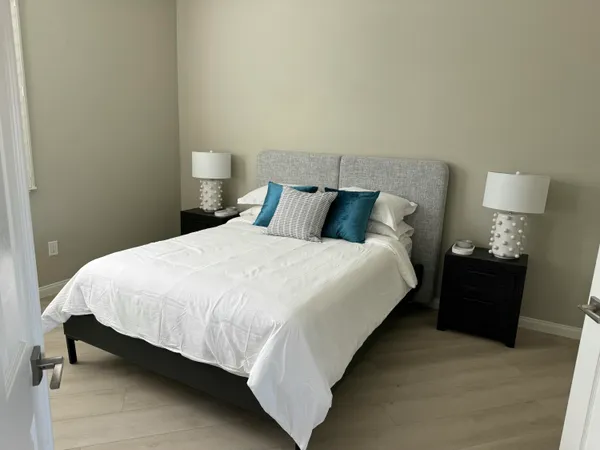 a large bed sitting in a bedroom next to a lamp