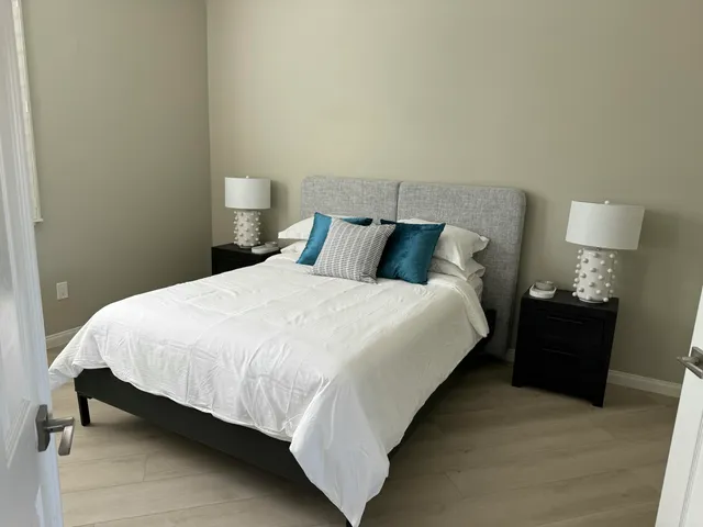 a large bed sitting in a bedroom next to a lamp