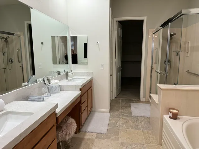 a bathroom with a granite countertop sink a mirror and a bathtub