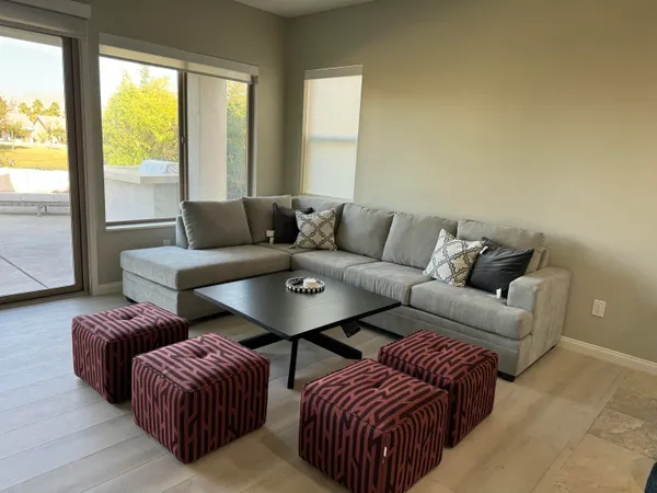 a living room with furniture and two large window