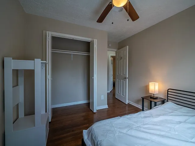 a spacious bedroom with a bed and a lamp