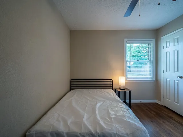 a bedroom with a bed and wooden floor