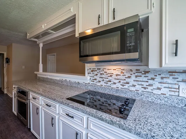 a kitchen with stainless steel appliances granite countertop a sink and a microwave