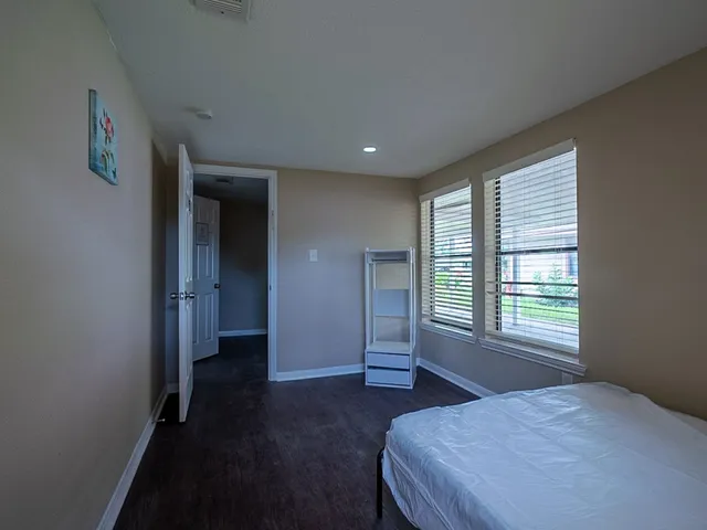 a spacious bedroom with a bed and a window