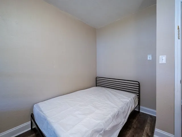 a bedroom with a bed and wooden floor