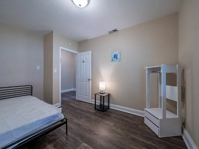 a bedroom with a bed and wooden floor