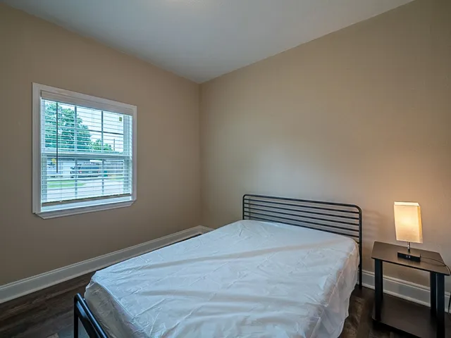 a bedroom with a bed and a window