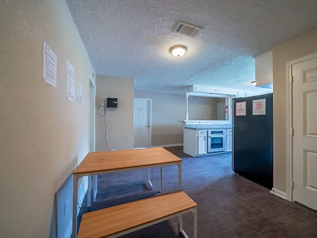 a bedroom with a bed and a view of kitchen