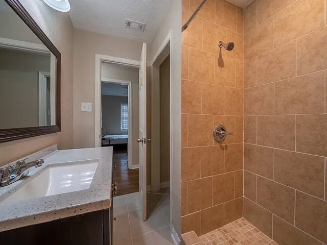 a bathroom with a granite countertop sink a toilet and a mirror