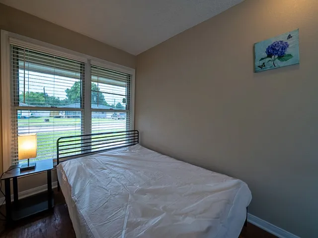 a bedroom with a bed and a large window