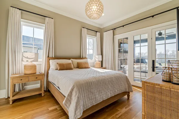 a bedroom with a large bed and a chandelier