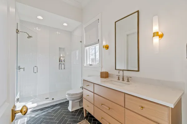 a bathroom with a double vanity sink toilet and shower