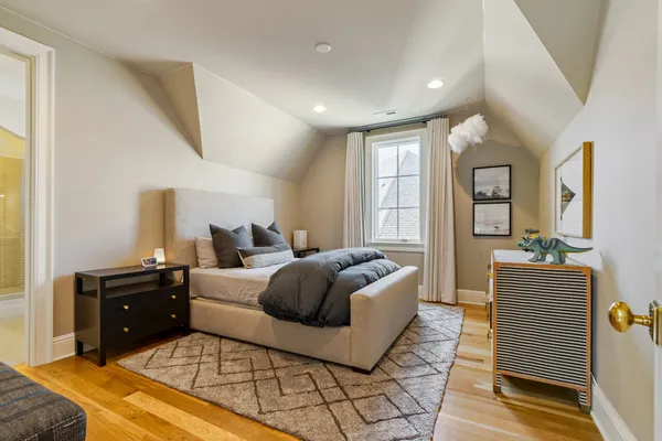 a bedroom with a bed a large window with furniture