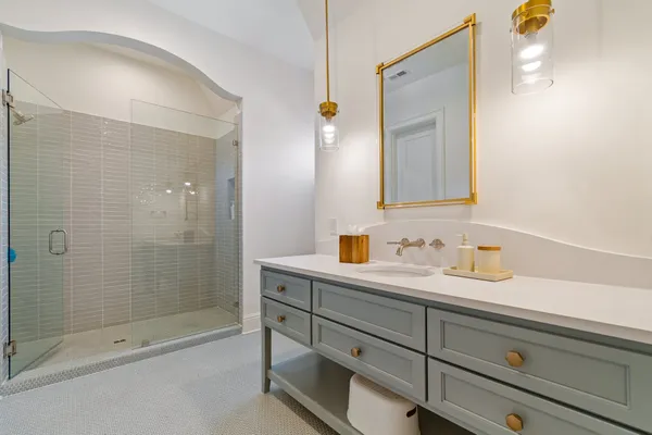 a bathroom with a shower sink vanity mirror and toilet