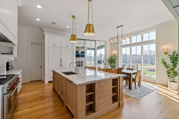 a kitchen with stainless steel appliances granite countertop a stove and a wooden floors