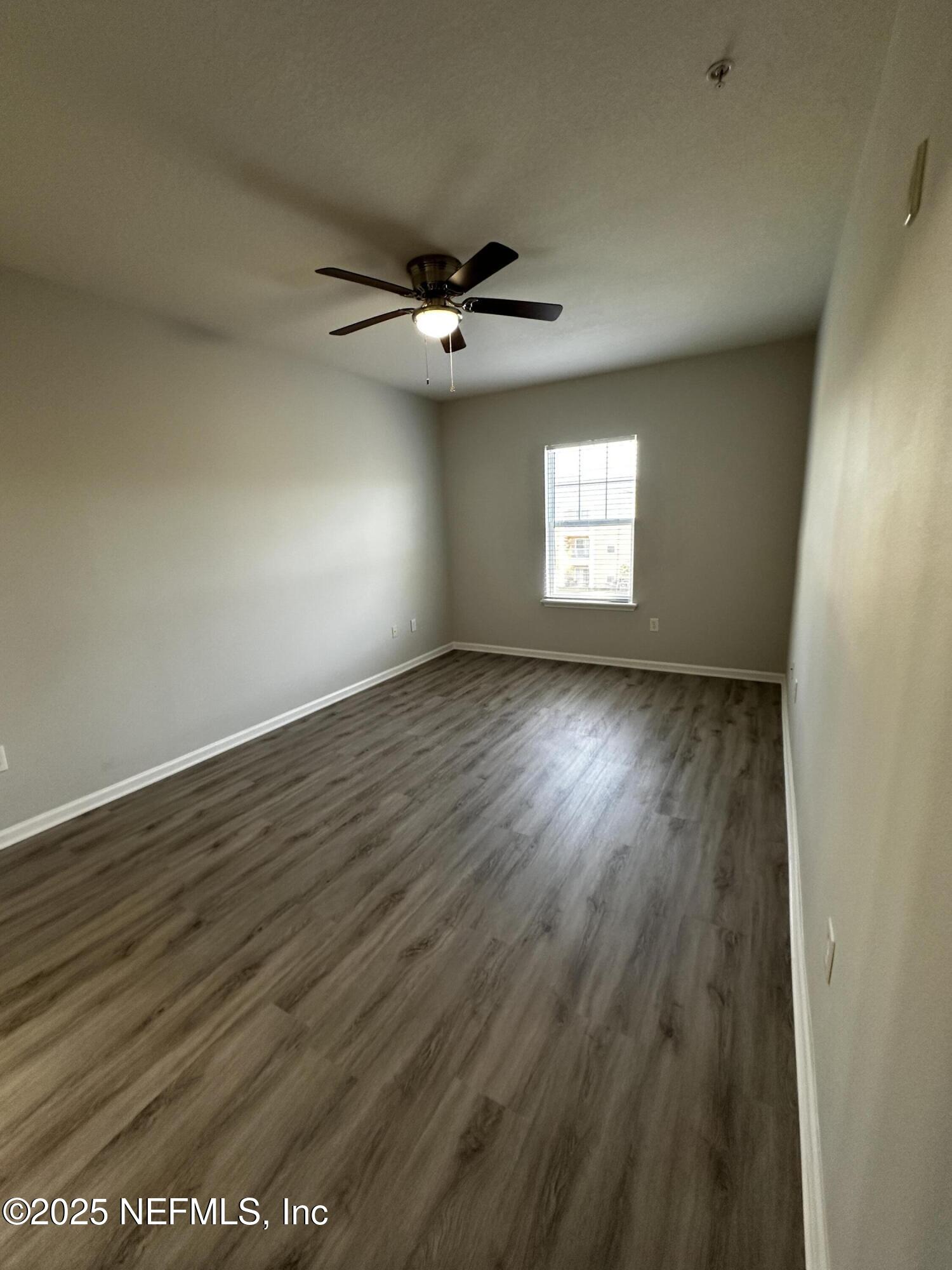 4917 Key Lime Drive, Unit 306 Jacksonville, FL 32256 - Photo 19 of 51 an empty room with wooden floor and windows