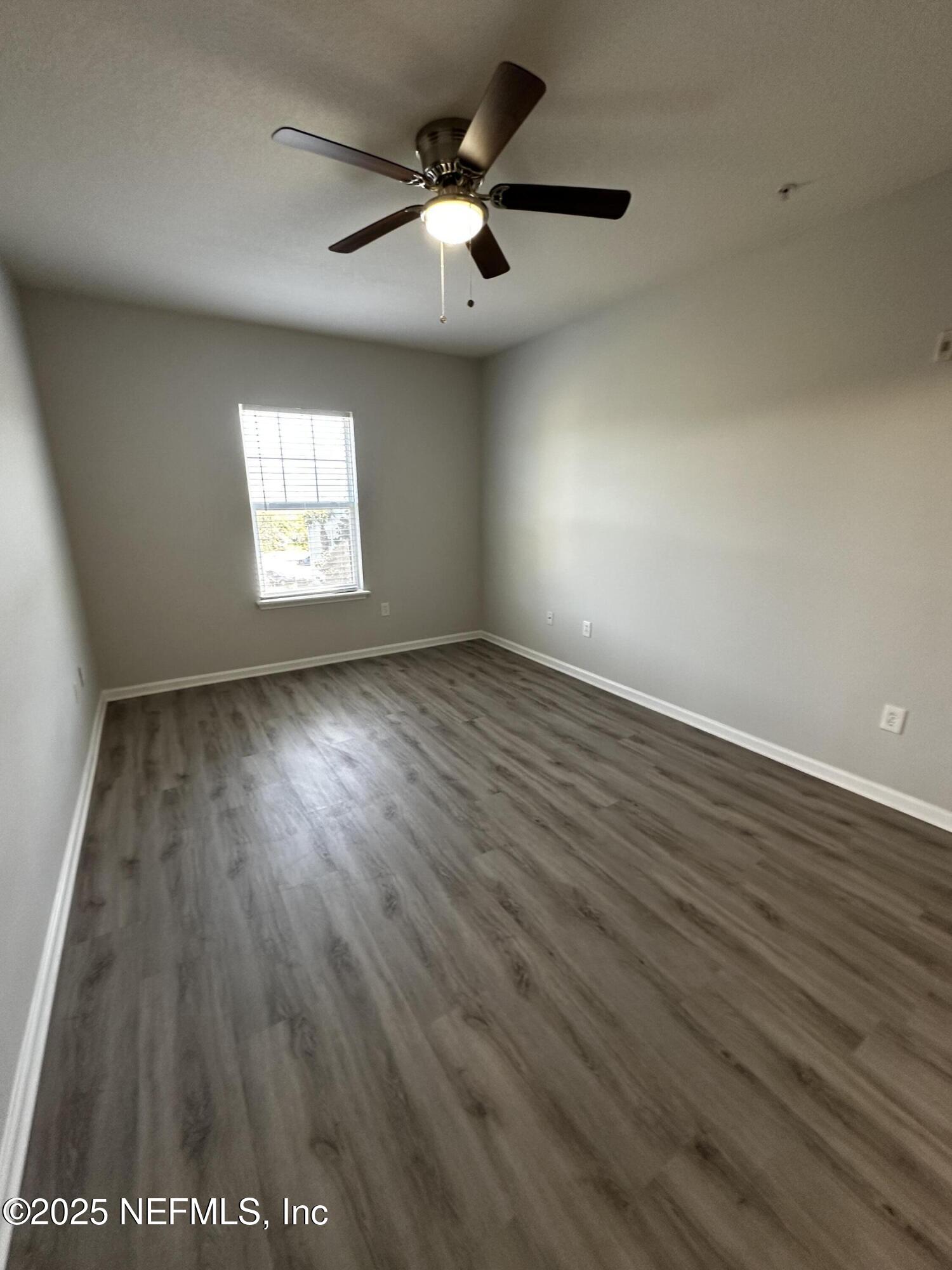 4917 Key Lime Drive, Unit 306 Jacksonville, FL 32256 - Photo 20 of 51 an empty room with wooden floor and windows