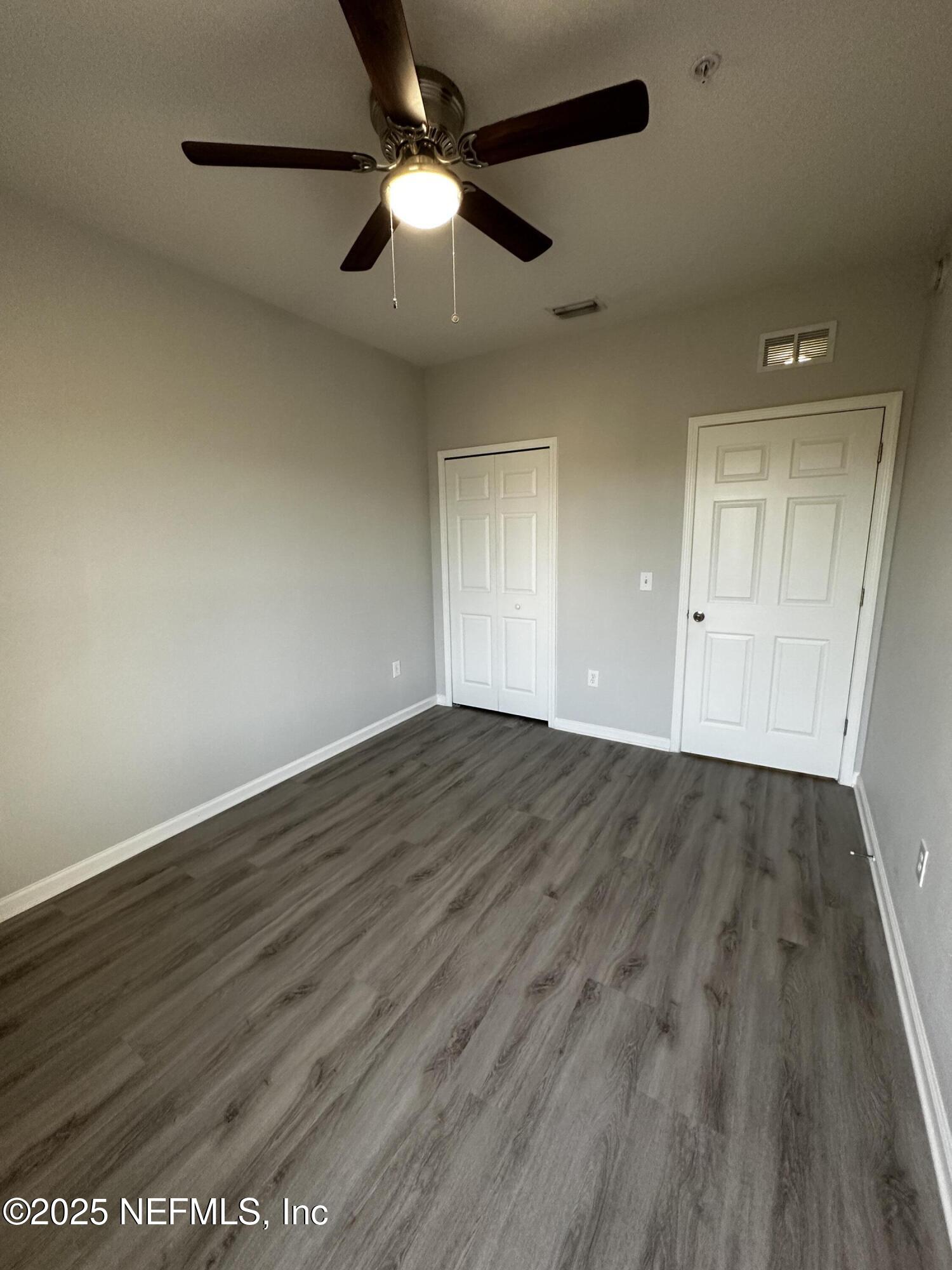 4917 Key Lime Drive, Unit 306 Jacksonville, FL 32256 - Photo 25 of 51 an empty room with wooden floor and windows