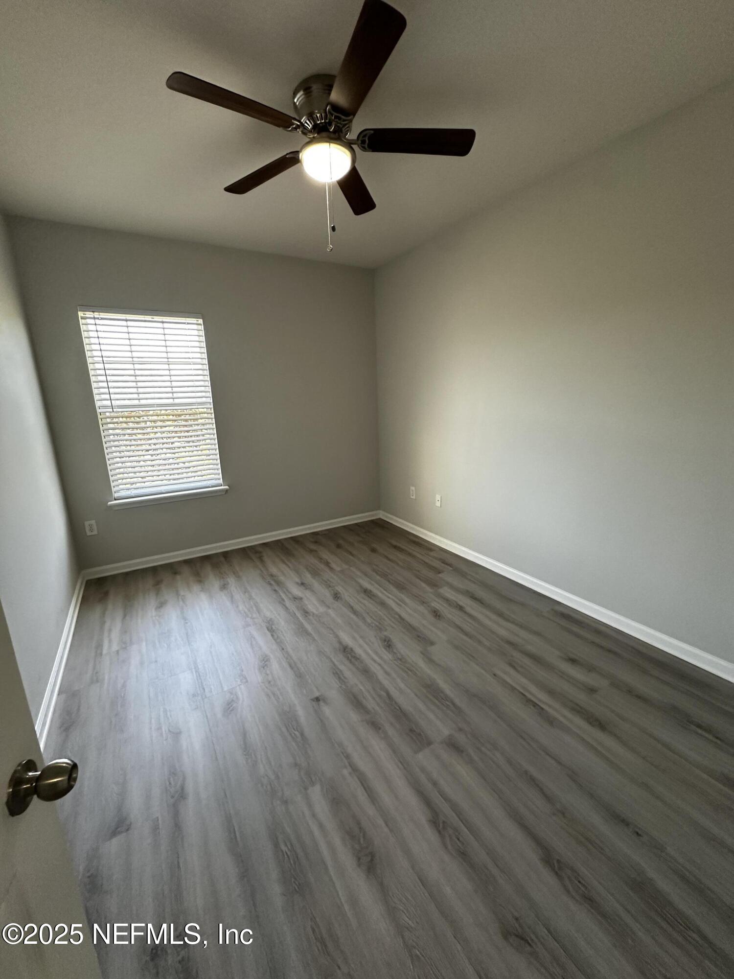 4917 Key Lime Drive, Unit 306 Jacksonville, FL 32256 - Photo 26 of 51 an empty room with wooden floor fan and windows