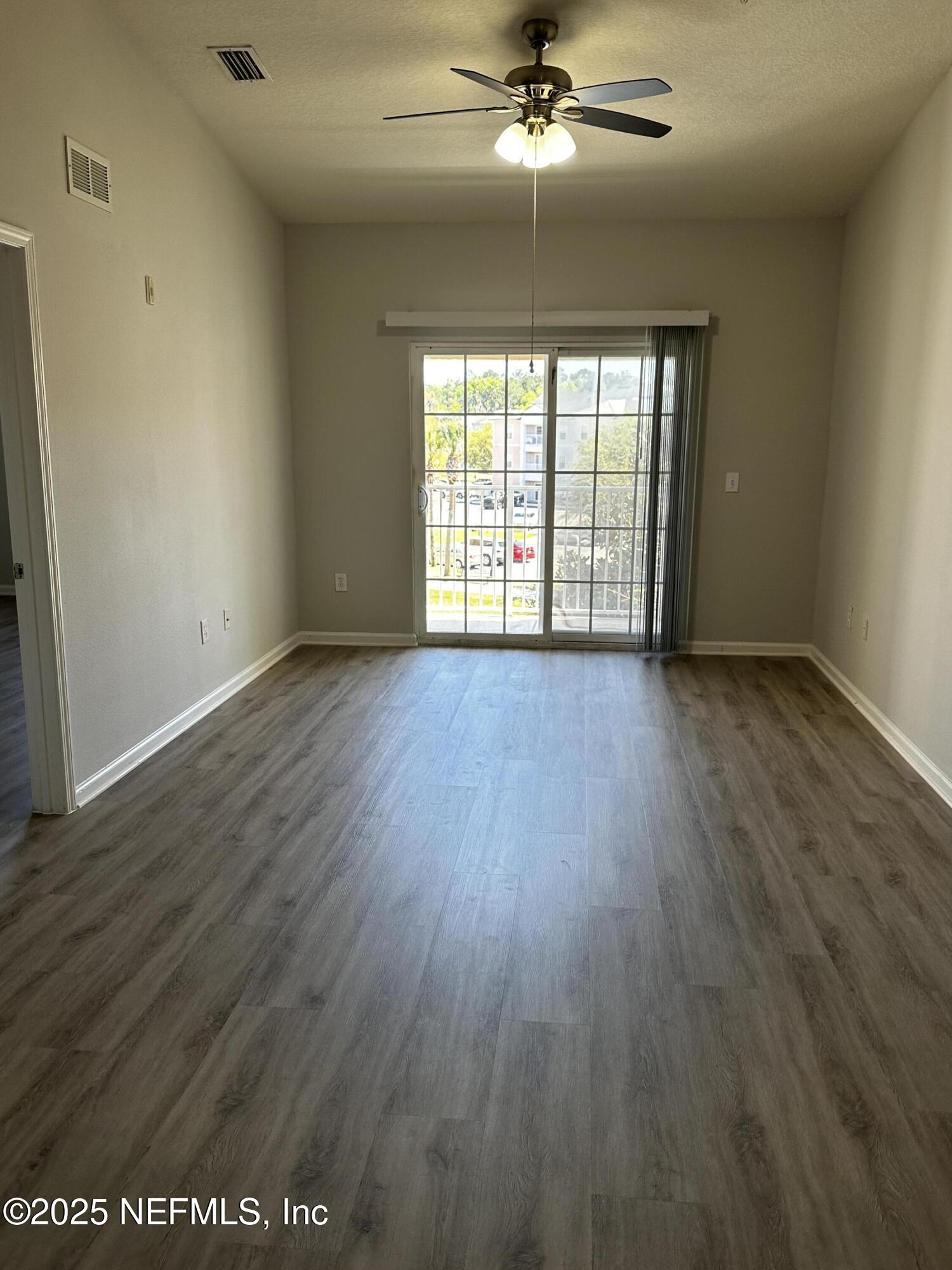 4917 Key Lime Drive, Unit 306 Jacksonville, FL 32256 - Photo 7 of 51 wooden floor in an empty room with a window