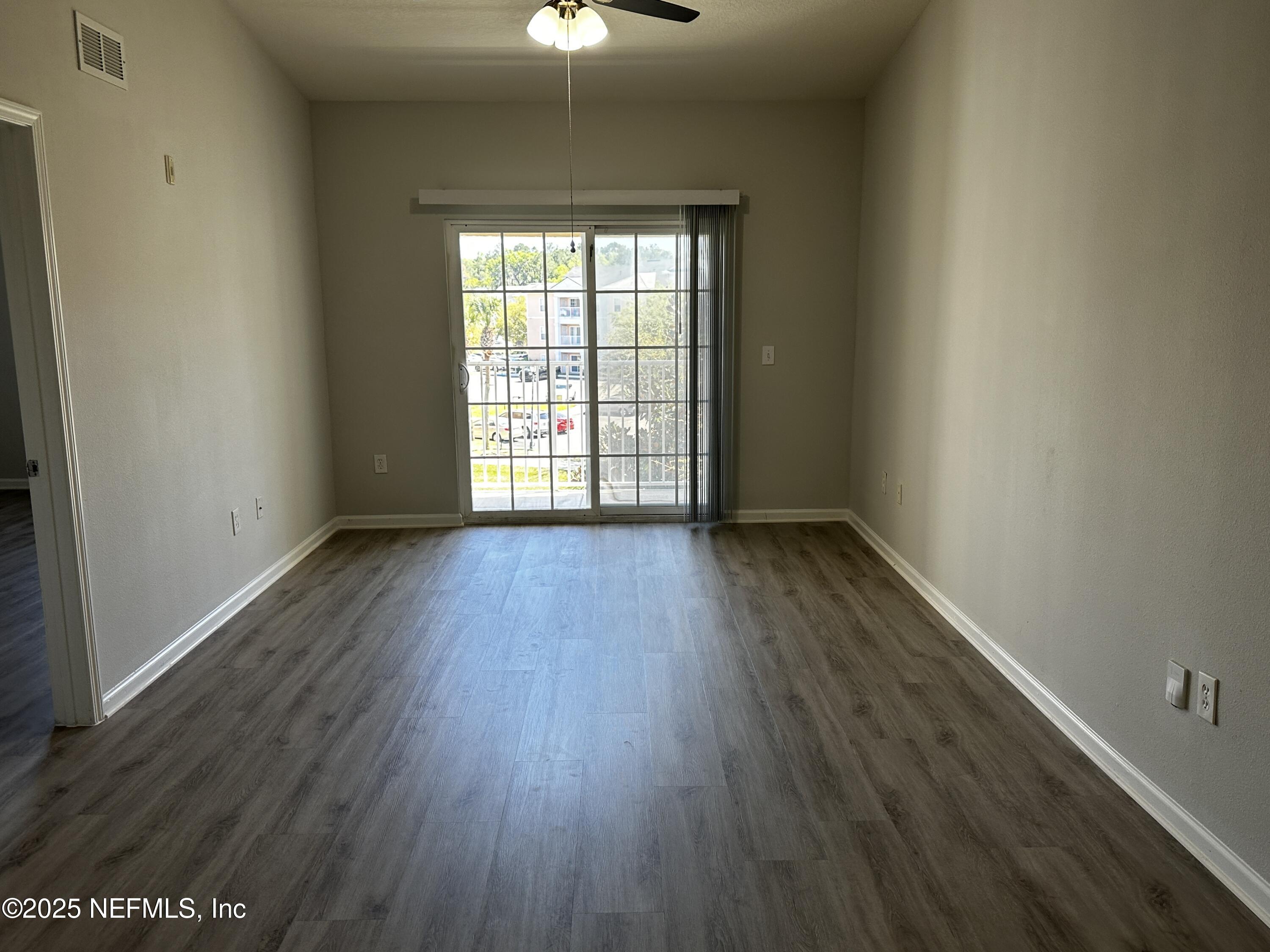 4917 Key Lime Drive, Unit 306 Jacksonville, FL 32256 - Photo 8 of 51 wooden floor in an empty room with a window