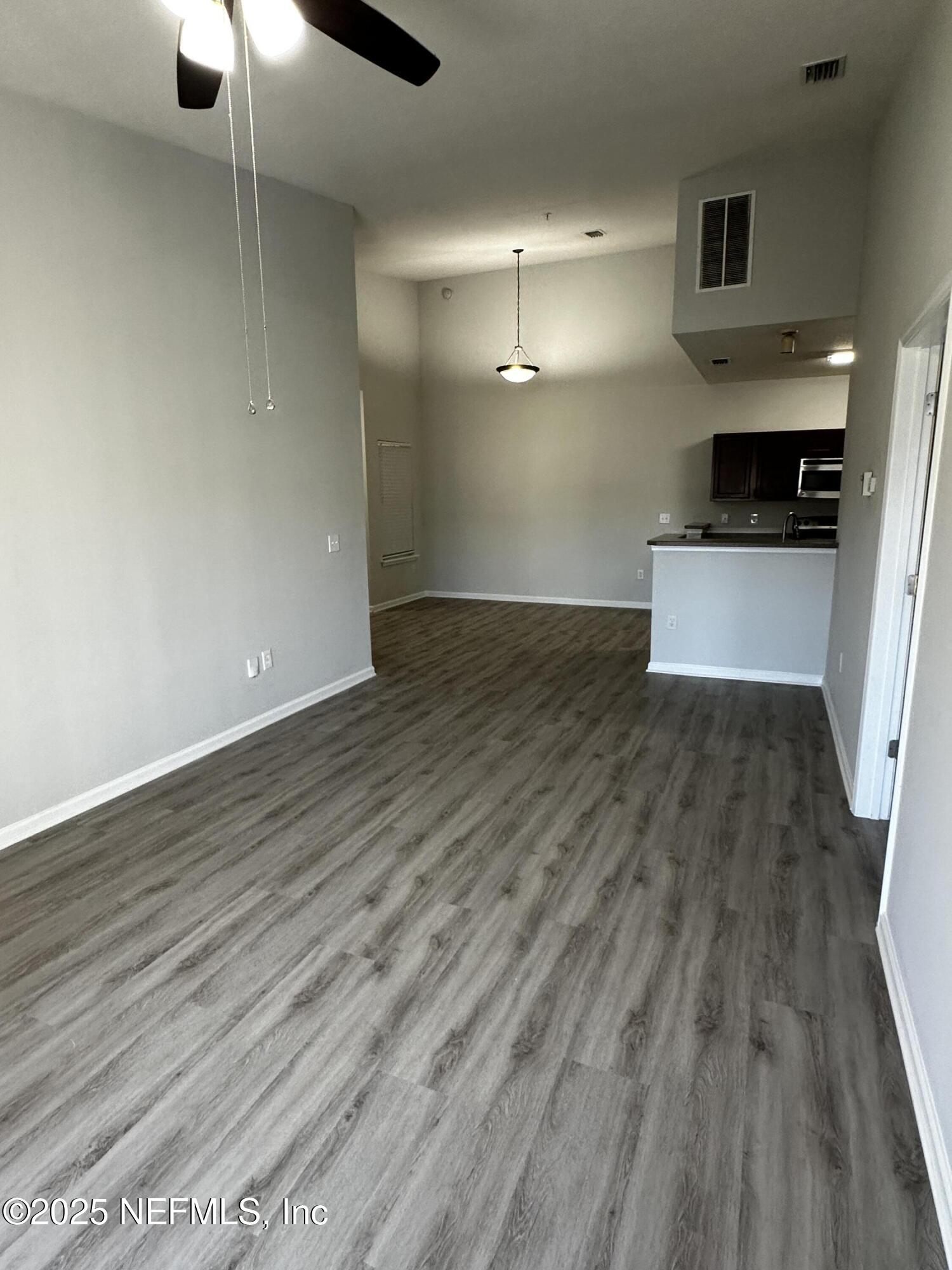 4917 Key Lime Drive, Unit 306 Jacksonville, FL 32256 - Photo 9 of 51 wooden floor in an empty room with a fireplace