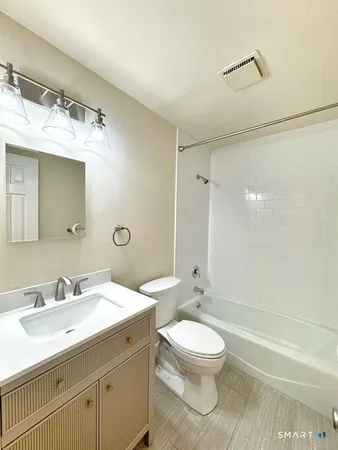 a bathroom with a sink toilet a mirror and shower