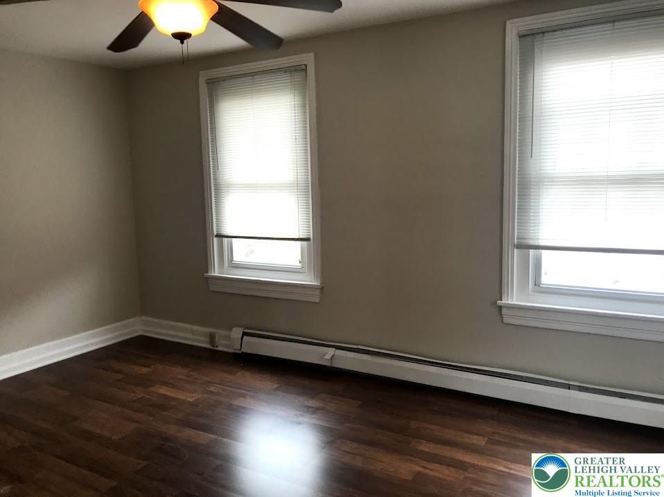 601 Pawnee Street Bethlehem, PA 18015 - Photo 3 of 6 an empty room with wooden floor and windows
