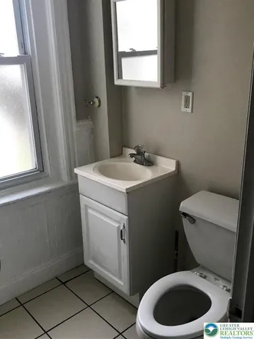 a bathroom with a toilet sink vanity and mirror