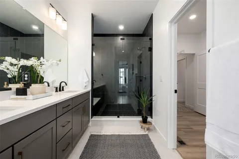 a bathroom with a sink shower and a mirror