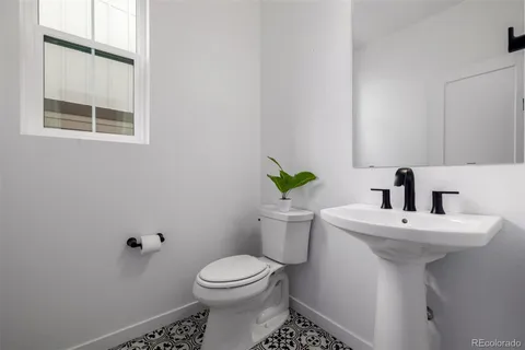 a bathroom with a sink toilet and a mirror