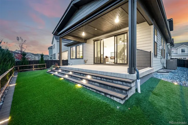 a backyard of a house with garden and wooden fence