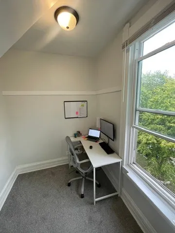 a view of a workspace with furniture and a window