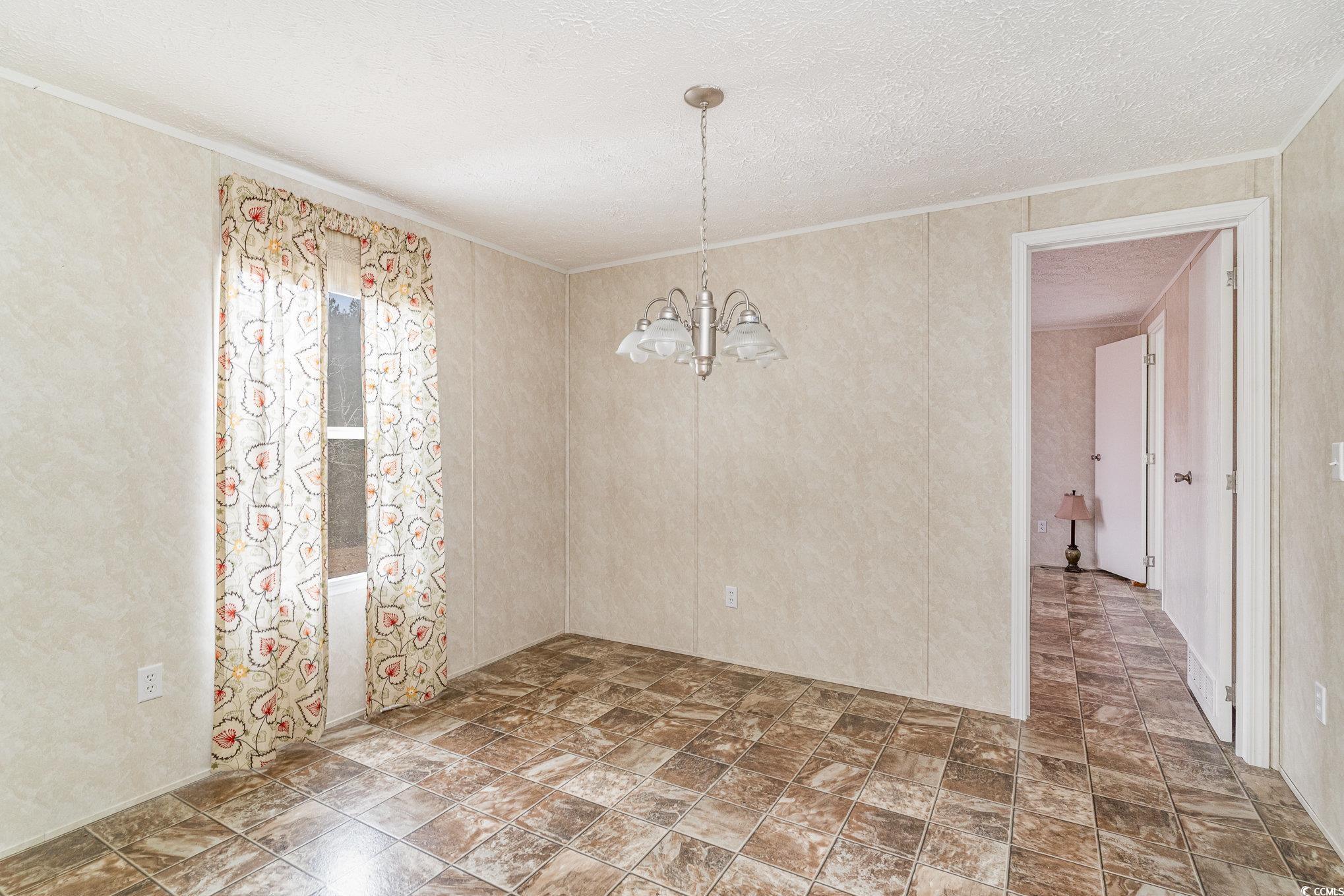 16048 Choppee Road Hemingway, SC 29554 - Photo 15 of 37 Empty room featuring crown molding, a textured cei