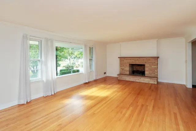 wooden floor fireplace and natural light in room