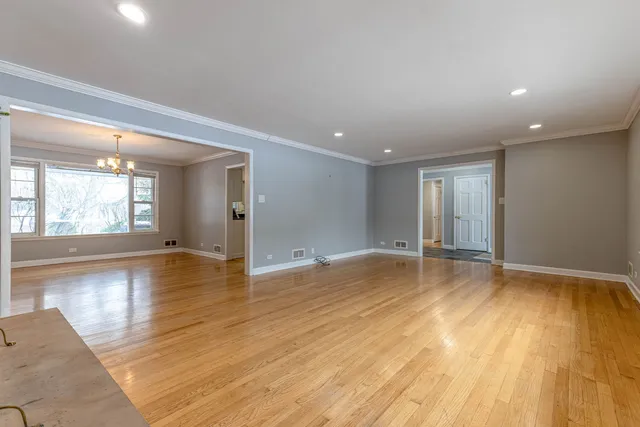 a view of empty room with wooden floor and floor to ceiling window