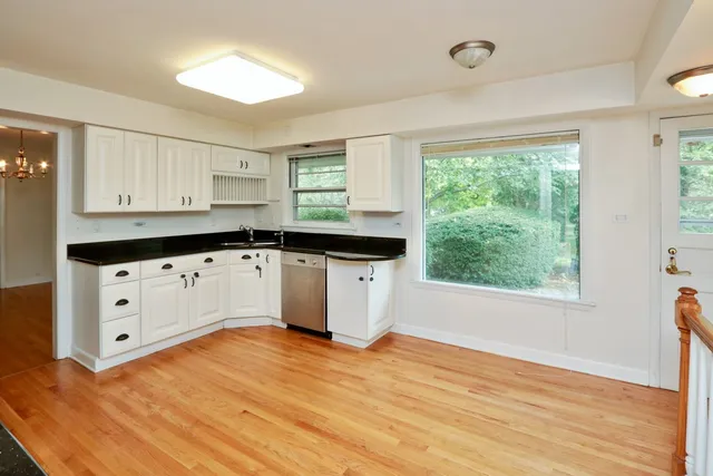 a kitchen with granite countertop a sink window and cabinets