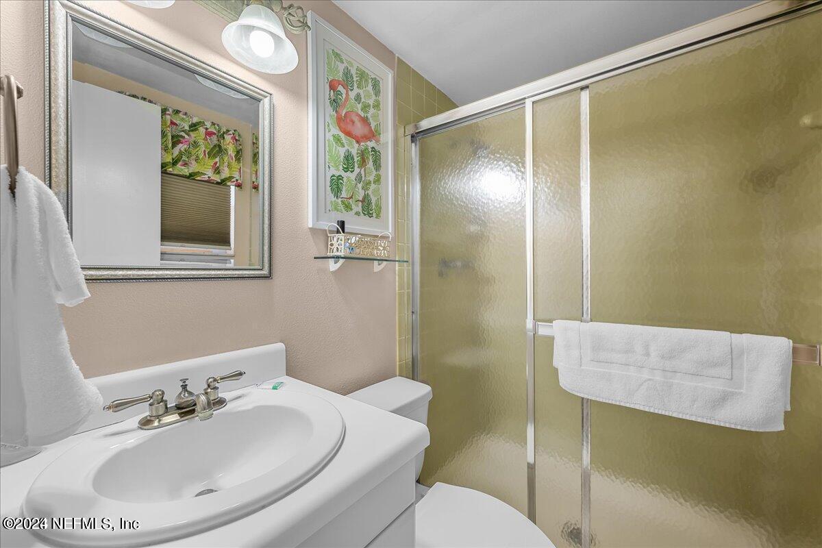5930 Florida A1A, Unit 8E St. Augustine, FL 32080 - Photo 5 of 31 a bathroom with a sink and mirror with toilet