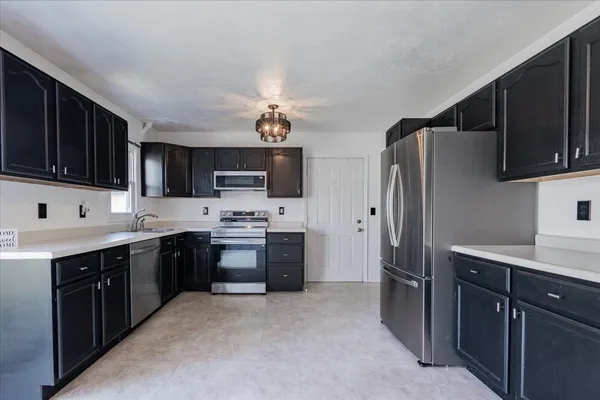 a kitchen with stainless steel appliances a stove sink refrigerator microwave and cabinets