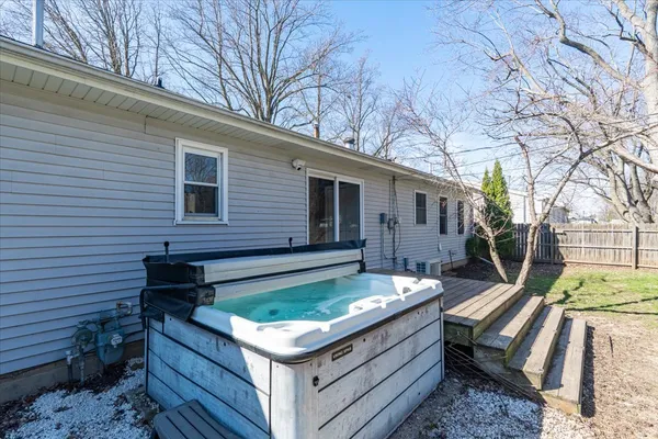 a view of a backyard with chairs and wooden fence