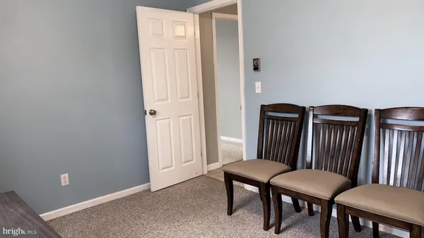 a view of an empty room with a chandelier fan