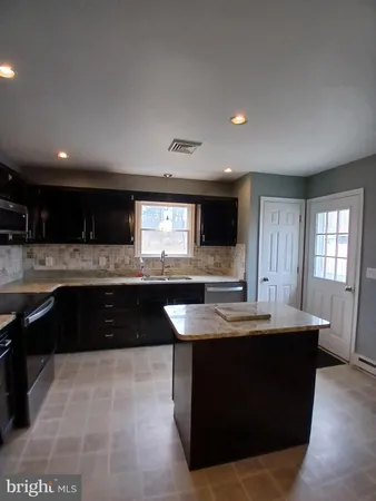 a kitchen with stainless steel appliances granite countertop a stove a refrigerator a sink and a oven