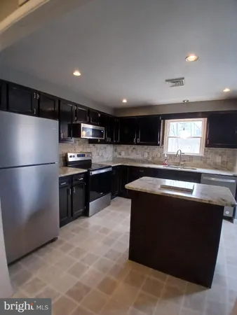a kitchen with a sink and a stove top oven with wooden floor